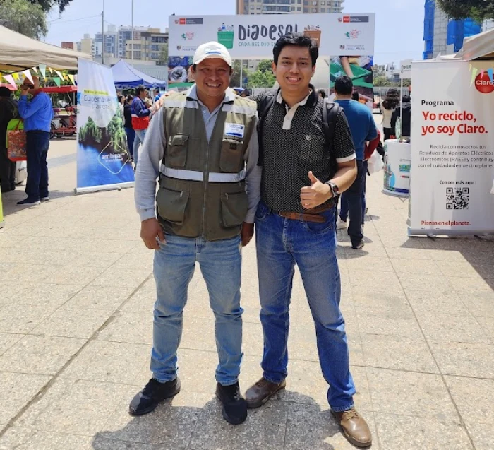 Reganvi con un reciclador en una feria de reciclaje en Lima
